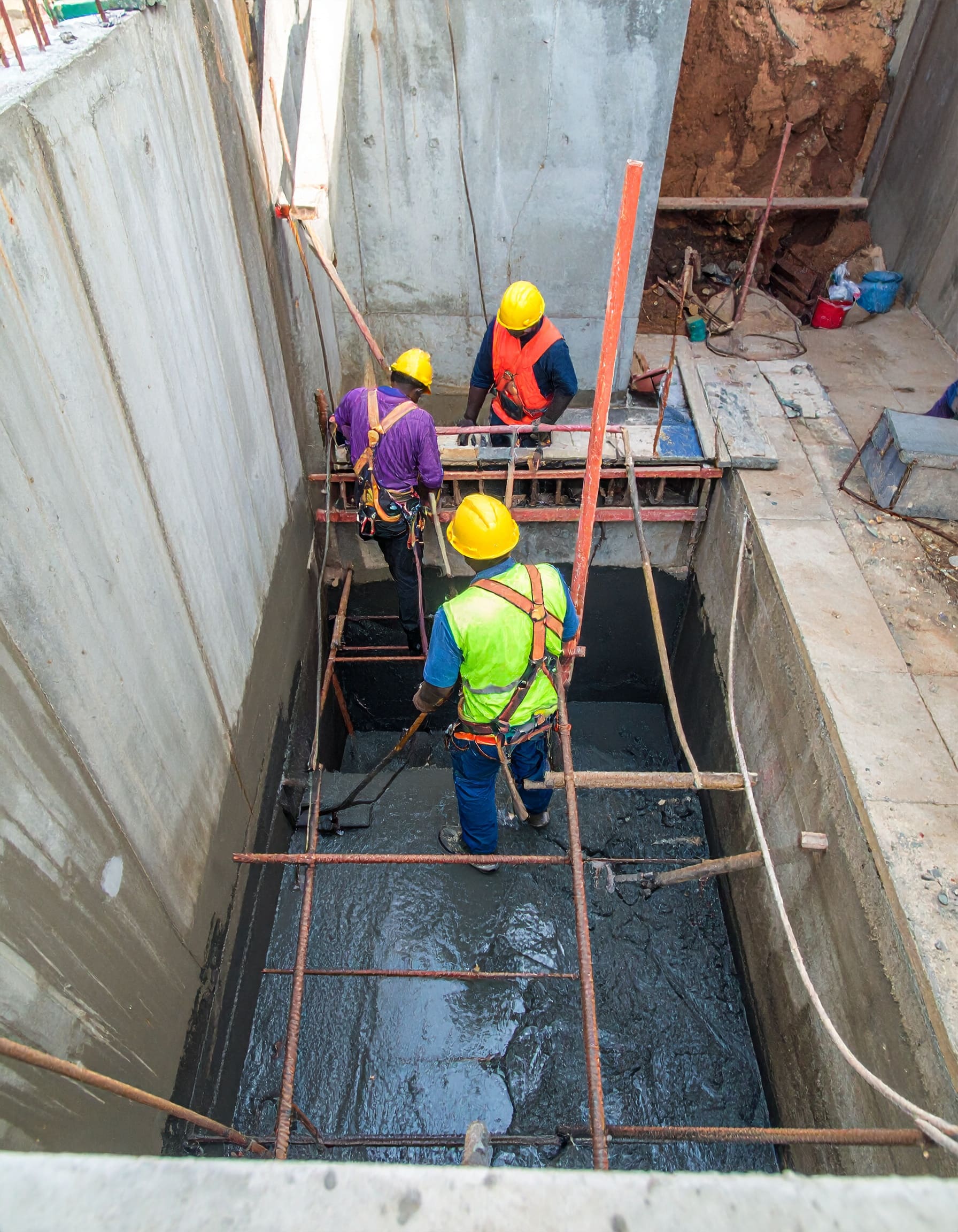 Firefly_A realistic image of African technicians waterproofing a vertical concrete lift shaft 324721