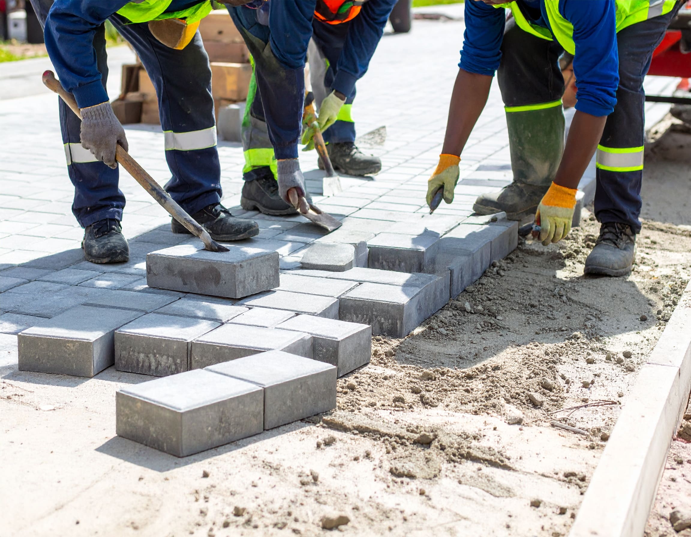 Firefly_A realistic image showing African workers installing cabro paving blocks on a drivewa 355747