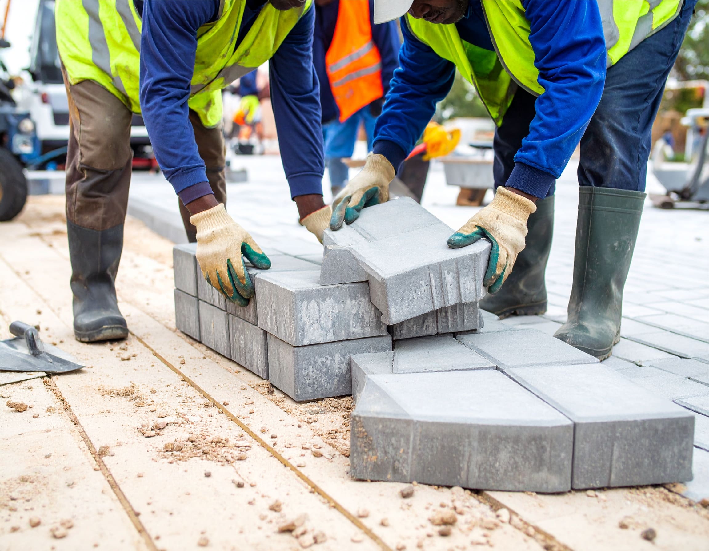 Firefly_A realistic image showing African workers installing cabro paving blocks on a drivewa 94726